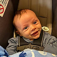 Orion joined the competition — help win amazing prizes! baby, car_seat, smiling, blanket, dinosaur_pattern, blue_clothing, safety_harness, cute, infant, face, child, indoors, happy, young_child, head, person, seatbelt, close_up, portrait, toddler