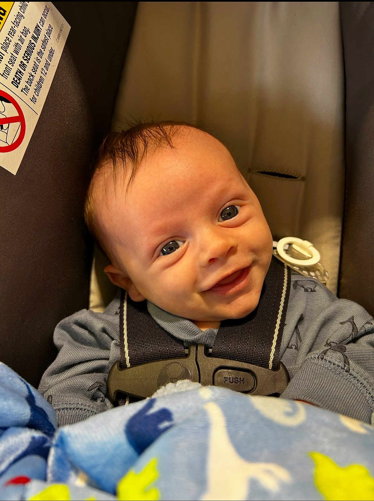Orion joined the competition — help win amazing prizes! baby, car_seat, smiling, blanket, dinosaur_pattern, blue_clothing, safety_harness, cute, infant, face, child, indoors, happy, young_child, head, person, seatbelt, close_up, portrait, toddler