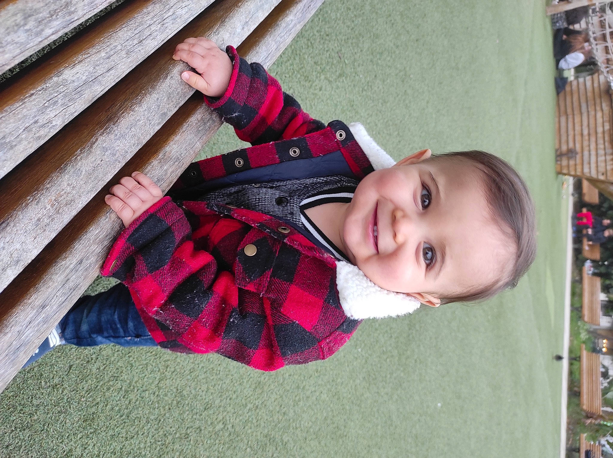 Aylan participe au concours pour gagner de l'argent avec cette photo : baby, baby_toddler_clothing, child, face, facial_expression, fun, grass, happy, joy, leaf, mammal, pattern, person, pink, plaid, skin, smile, standing, tartan, toddler