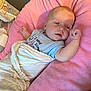 baby, blanket, pink, cushion, sleepy, infant, onesie, clothing, face, person, resting, soft, indoor, cute, child, wrapped, newborn, lying_down, relaxed, cozy