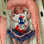 Autumn joined the competition — help win amazing prizes! baby, infant, pink_cushion, blanket, clothing, skirt, polka_dot, red_ribbon, white_shirt, text_on_clothing, face, legs, arms, towel, indoor, soft_lighting, cute, newborn, person, portrait