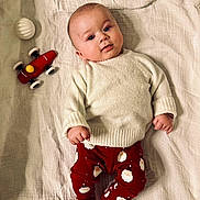 Ezio a rejoint le concours — aidez-le/la à gagner de superbes lots ! baby, infant, blanket, toy_car, white_ball, red_pants, santa_print, sweater, lying_down, cute, child, face, fingers, feet, indoors, soft_texture, expression, looking_at_camera, playtime, holiday_theme