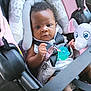K'La is registered to the contest to win money with this photo: baby, baby_girl, black_hair, car_interior, car_seat, child, close_up, clothing, cute, elephant_toy, indoors, infant, pacifier, plush_toy, portrait, safety, seat, seatbelt, soft_toy, young_child