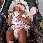 K'La joined the competition — help win amazing prizes! baby, infant, pacifier, headband, stroller, pink_socks, floral_outfit, child, cute, indoors, seat, comfort, portrait, young_child, clothing, baby_accessory, relaxing, small_person, adorable, baby_bib