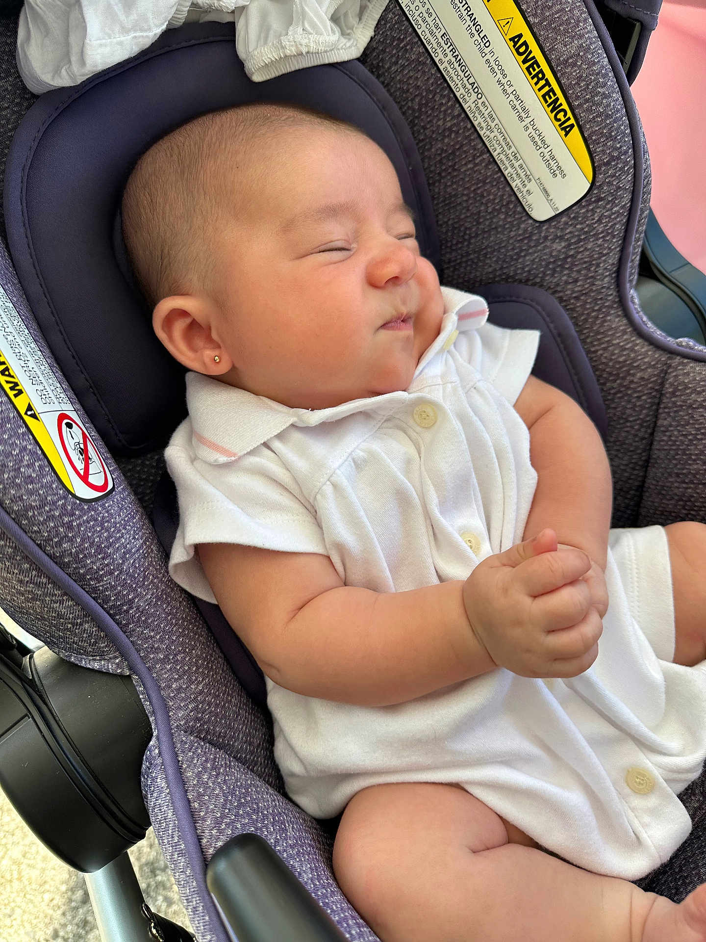 Willow joined the competition — help win amazing prizes! baby, infant, car_seat, white_clothing, earring, scrunched_face, cute, child, seat_belt_warning, purple_car_seat, expressive_face, small_hands, indoors, newborn, adorable, comfortable, casual_clothing, human, portrait, resting