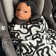 Trea joined the competition — help win amazing prizes! baby, infant, car_seat, blanket, headband, black_and_white, pattern, child, seatbelt, cute, portrait, indoors, wrapped, young_child, newborn, person, face, looking, comfort, soft_fabric
