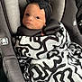 baby, infant, car_seat, blanket, headband, black_and_white, pattern, child, seatbelt, cute, portrait, indoors, wrapped, young_child, newborn, person, face, looking, comfort, soft_fabric