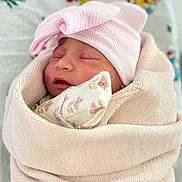 Annelise is registered to the contest to win money with this photo: newborn, baby, infant, sleeping, pink_hat, swaddled, blanket, floral_bedding, portrait, face, closed_eyes, peaceful, cozy, indoors, textile, soft_lighting, headwear, infant_clothing, nursery, photography