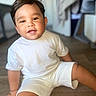baby, blurred_background, bright, child, cute, face, hair, happy, indoors, person, portrait, shorts, sitting, skin, smiling, toddler, tshirt, white_clothing, wooden_floor, young_child