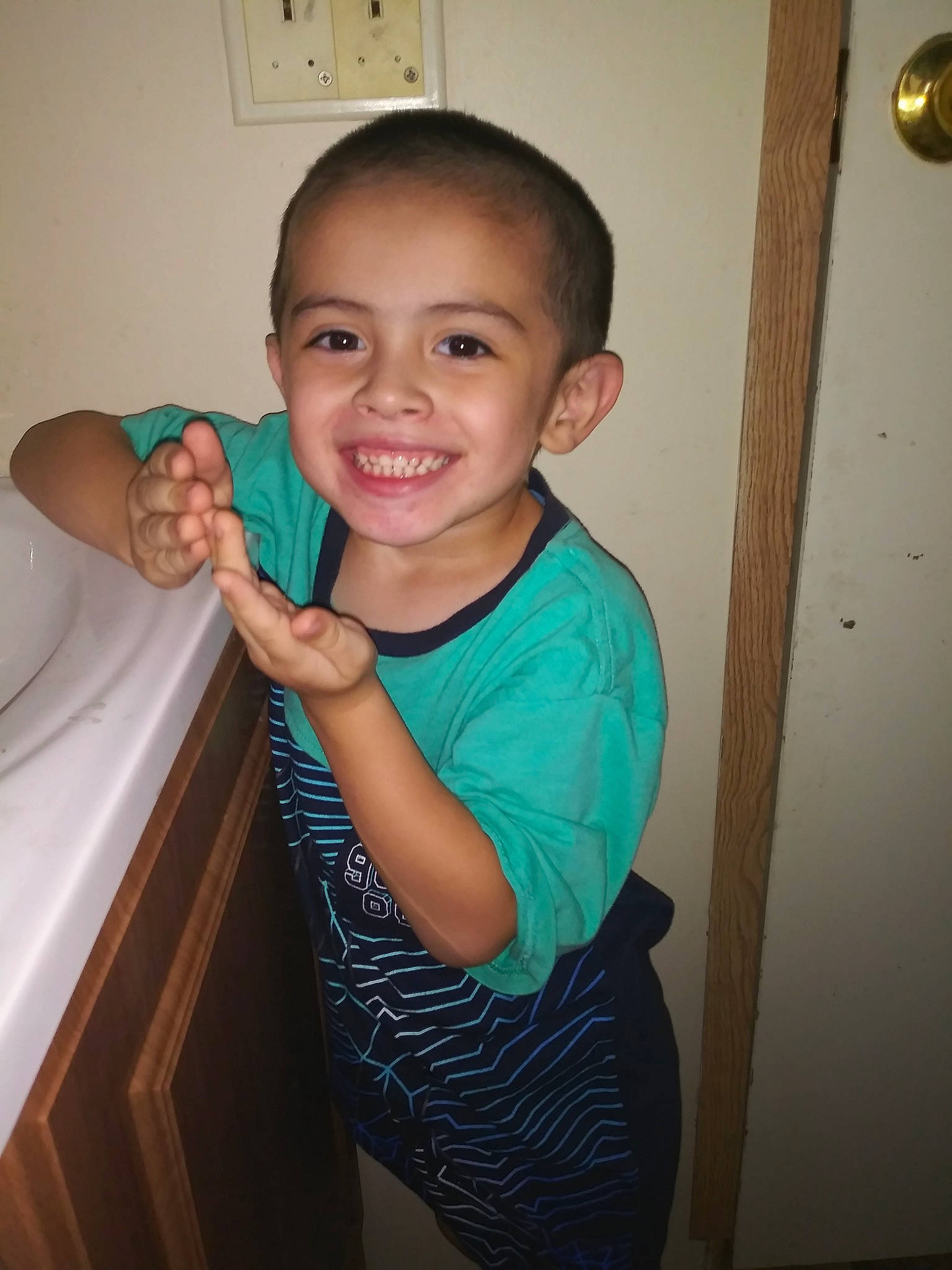 Izik is registered to the contest to win money with this photo: arm, child, ear, face, finger, happy, head, joint, joy, muscle, person, room, shoulder, smile, standing, t_shirt, thumb, toddler, tooth