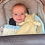 Charlie is registered to the contest to win money with this photo: baby, smiling, plush_toy, blanket, stroller, cozy, child, infant, face, happy, blue_eyes, clothing, seatbelt, soft, cute, indoors, portrait, comfort, warm, baby_care