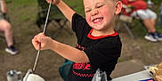 Porter is registered to the contest to win money with this photo: child, boy, marshmallow, camping, outdoor, smiling, food, graham_crackers, table, picnic, roasting, stick, happy, nature, forest, recreation, snack, summer, fun, playful