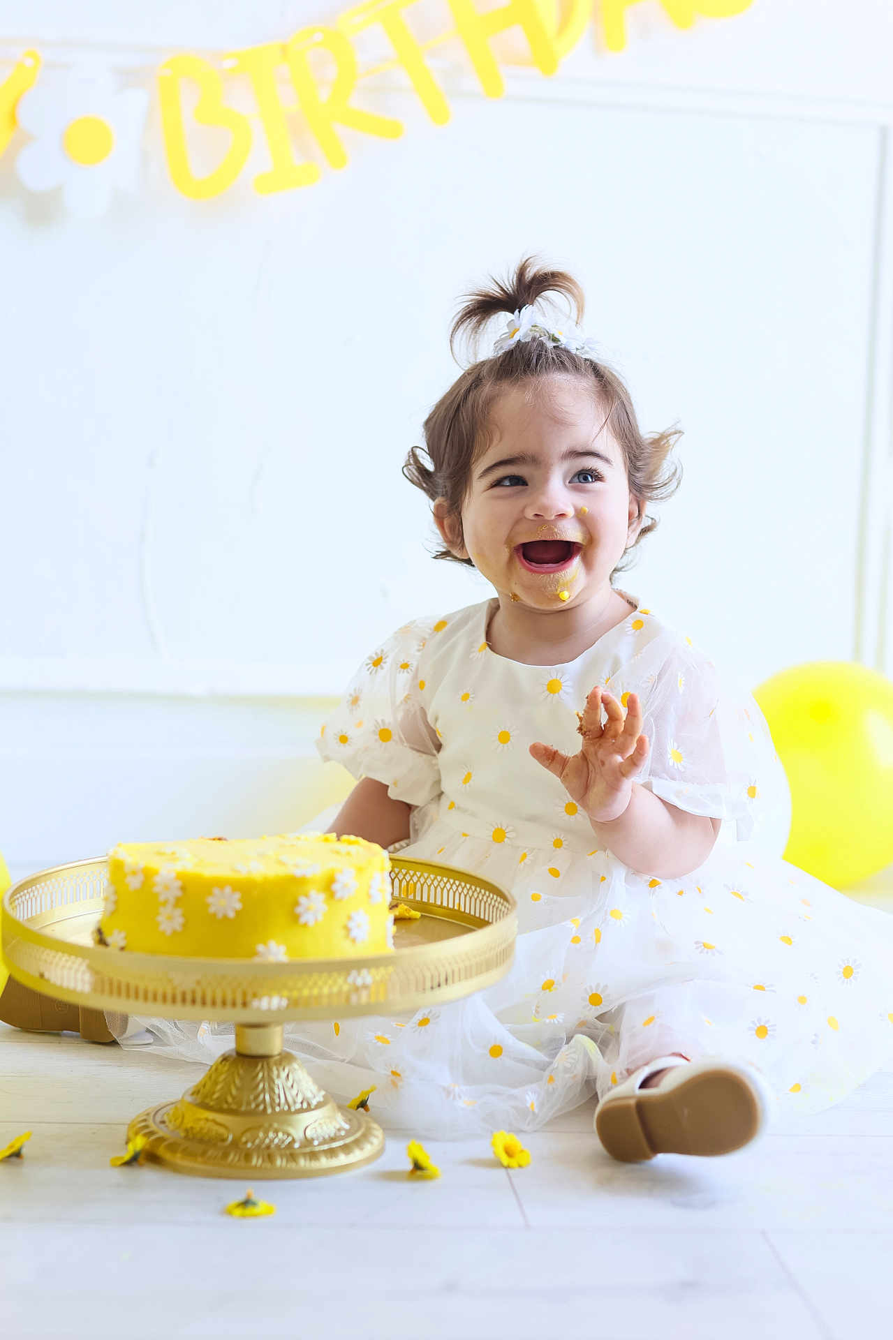 Janna participe au concours pour gagner de l'argent avec cette photo : toddler, child, birthday, cake, yellow, dress, smiling, happy, balloons, celebration, face_paint, flower, party, golden_cake_stand, white_background, floor, sitting, cute, playful, fun