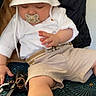 baby, belt, casual, child, cushion, cute, foot, hand, hat, indoor, infant, jacket, pacifier, patterned_fabric, relaxed, seat, shorts, sleeping, sock, white_clothing