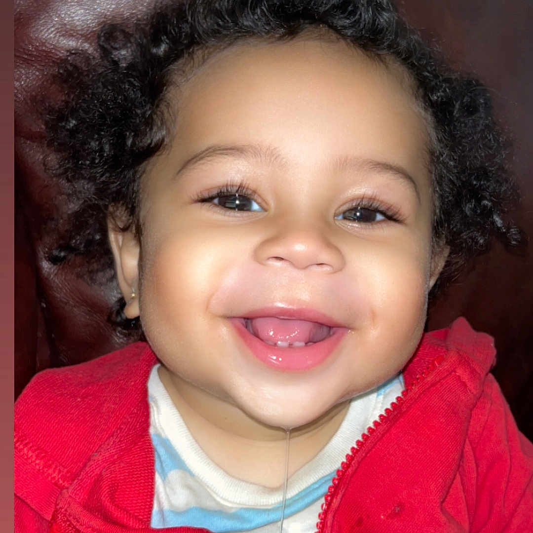 Chozen joined the competition — help win amazing prizes! baby, casual, child, clothing, curly_hair, cute, drool, expression, face, happy, indoor, leather_background, person, portrait, red_jacket, sitting, smile, teeth, toddler, young_child