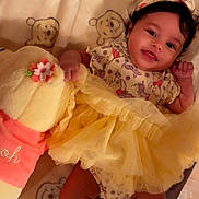 River is registered to the contest to win money with this photo: baby, infant, smiling, yellow_dress, headband, plush_toy, winnie_the_pooh, blanket, cute, lying_down, child, indoors, happy, soft_toy, patterned_clothing, feet, hand, portrait, adorable, cozy