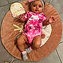 Mayannah a rejoint le concours — aidez-le/la à gagner de superbes lots ! baby, infant, pink_clothing, headband, bow, play_mat, toy, floor_tiles, socks, nike_logo, child, cute, lying_down, indoor, curious_expression, floral_pattern, soft_toy, wooden_toy, six_months, baby_girl