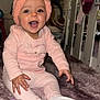 baby, child, pink_hat, toy, purple_toy, rug, carpet, indoor, smiling, happy, sitting, clothing, sock, nursery, furniture, play, cute, headwear, person, infant