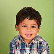 Cash joined the competition — help win amazing prizes! child, toddler, portrait, smiling, happy, face, eyes, hair, curly_hair, plaid_shirt, clothing, button, studio, green_background, indoor, headshot, front_facing, young_person, photography, cheerful