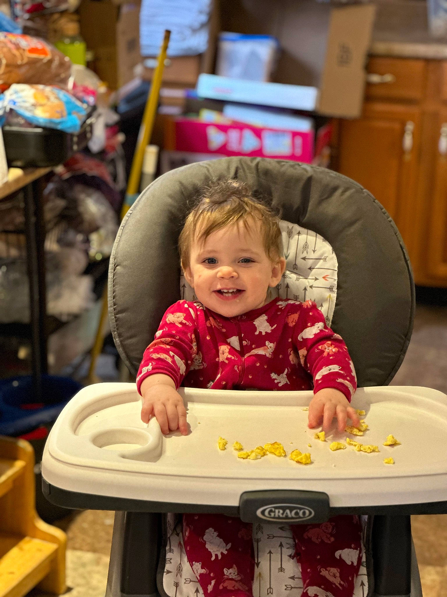 Piper is registered to the contest to win money with this photo: baby, cabinetry, chair, chest_of_drawers, child, comfort_food, event, food_craving, fun, happy, joy, leisure, person, play, recreation, room, sharing, sitting, smile, t_shirt