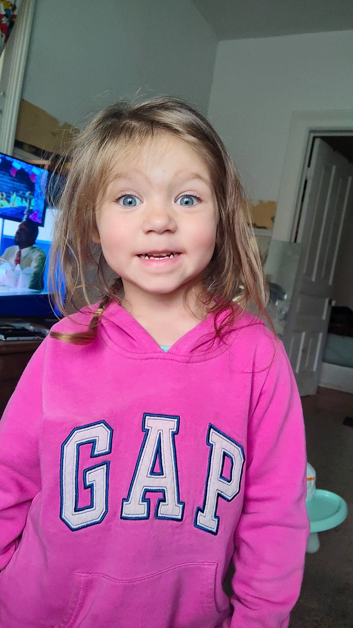 Chloe is registered to the contest to win money with this photo: cheek, child, chin, eyebrow, fun, hair, happy, head, iris, jersey, long_hair, person, pink, purple, skin, sleeve, smile, sportswear, standing, t_shirt