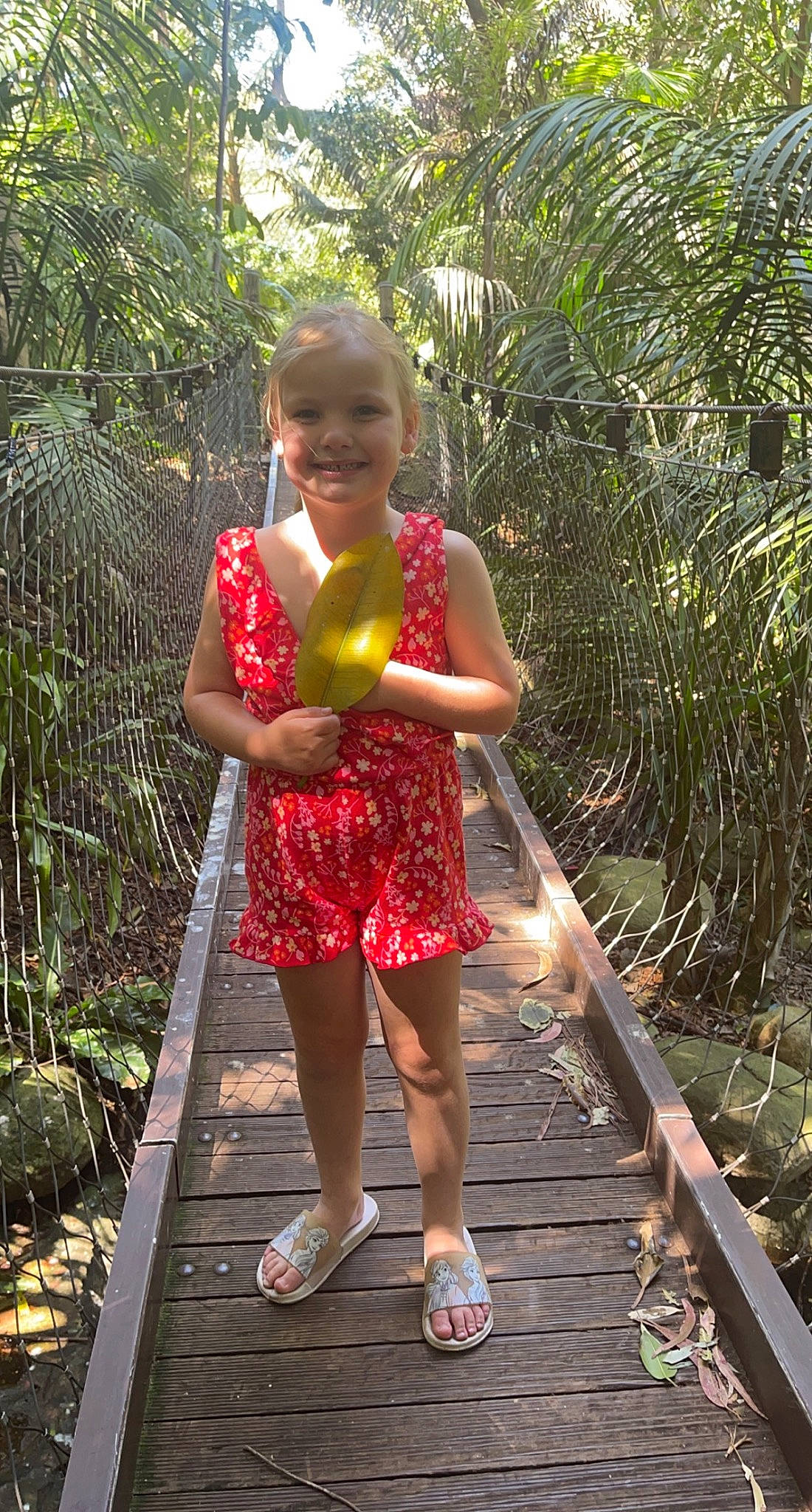Maddi is registered to the contest to win money with this photo: child, fruit, fun, garden, grass, happy, human_leg, joy, jungle, leisure, people_in_nature, person, plant, plantation, sandal, shoe, smile, terrestrial_plant, thigh, toddler