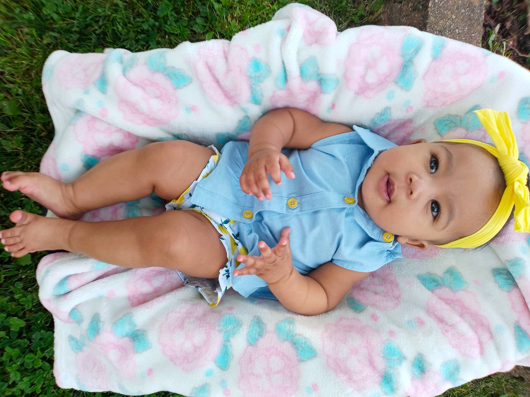 Journee is registered to the contest to win money with this photo: baby, baby_products, baby_toddler_clothing, blue, cheek, child, clothing, comfort, face, facial_expression, finger, grass, hand, headgear, leaf, pattern, person, pink, skin, sleeve