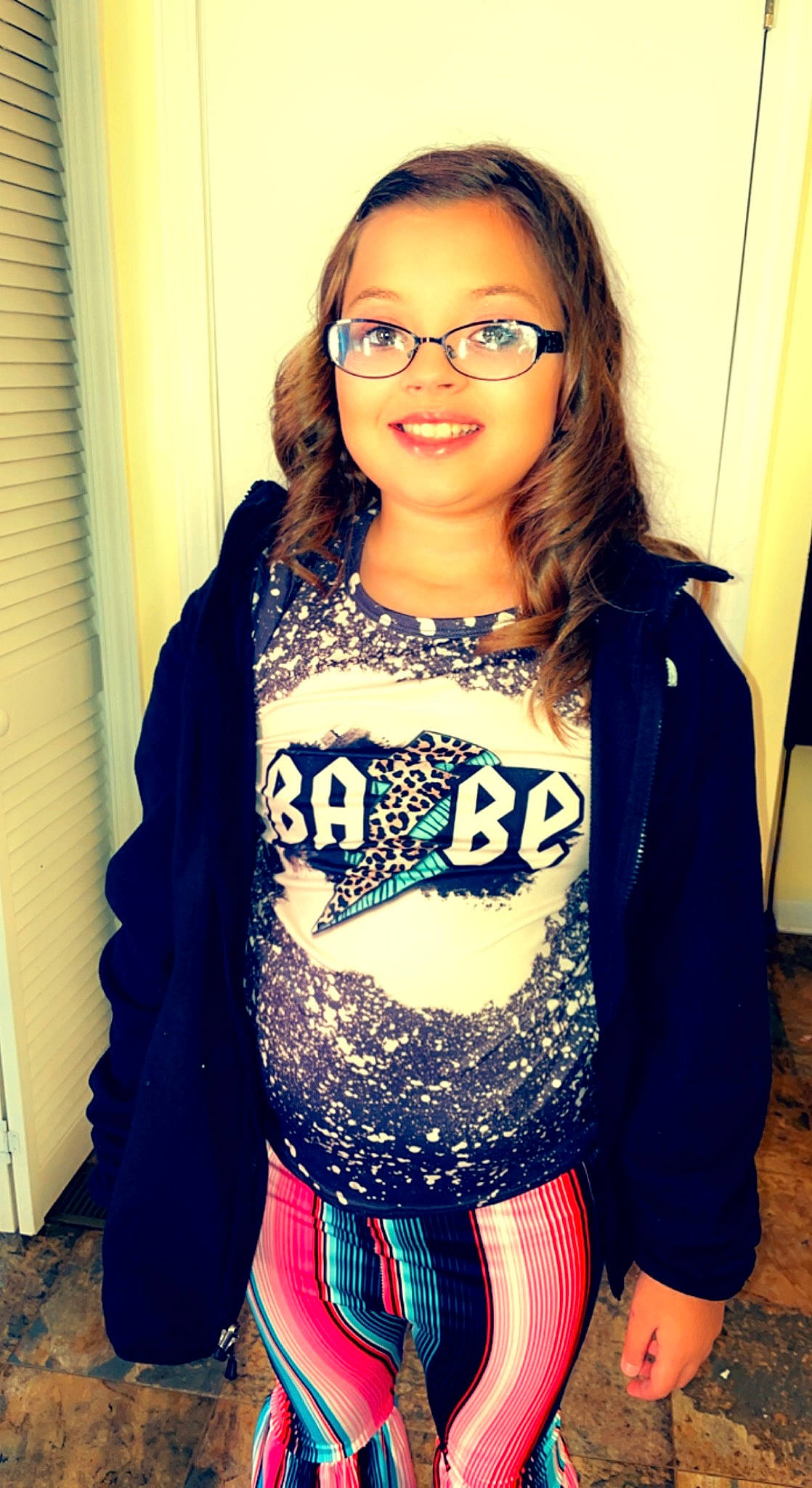 Lilly is registered to the contest to win money with this photo: black_hair, cool, eyewear, fashion_design, glasses, hair, happy, head, iris, joy, long_hair, outerwear, person, skin, sleeve, smile, t_shirt, textile, thigh, vision_care