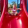 Dayton joined the competition — help win amazing prizes! toddler, child, slide, playground, red_slide, outdoor, daytime, happy, smiling, grass, trees, blue_sky, summer, casual_clothing, sneakers, fun, park, play, person, recreation