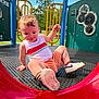 toddler, child, playground, slide, outdoor, summer, tree, blue_sky, sneakers, tank_top, shorts, play_equipment, happy, fun, daylight, grass, park, metal_platform, yellow_rails, red_slide