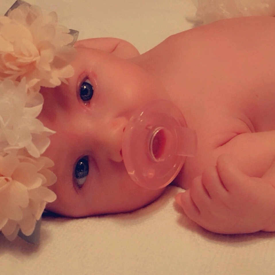Lacey is registered to the contest to win money with this photo: baby, cheek, chin, eyebrow, eyelash, face, flower, headgear, human_body, iris, lip, mouth, nail, nose, petal, pink, plant, skin, textile, toy