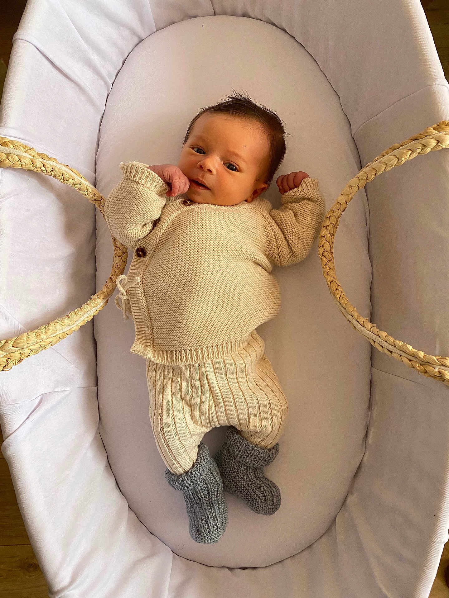 Ulysse a rejoint le concours — aidez-le/la à gagner de superbes lots ! newborn, baby, infant, bassinet, knitted_clothing, cream_color, gray_booties, cozy, cute, sleeping_area, soft_fabric, wooden_floor, indoors, resting, baby_fashion, portrait, small_hands, baby_booties, relaxing, child