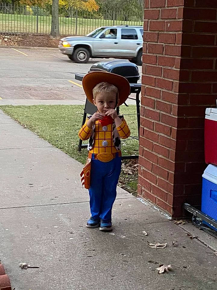 Jaxson is registered to the contest to win money with this photo: auto_part, brick, brickwork, compact_sport_utility_vehicle, driveway, family_car, fictional_character, figurine, hat, hubcap, overall, person, sidewalk, sport_utility_vehicle, toddler, toy, vehicle_door