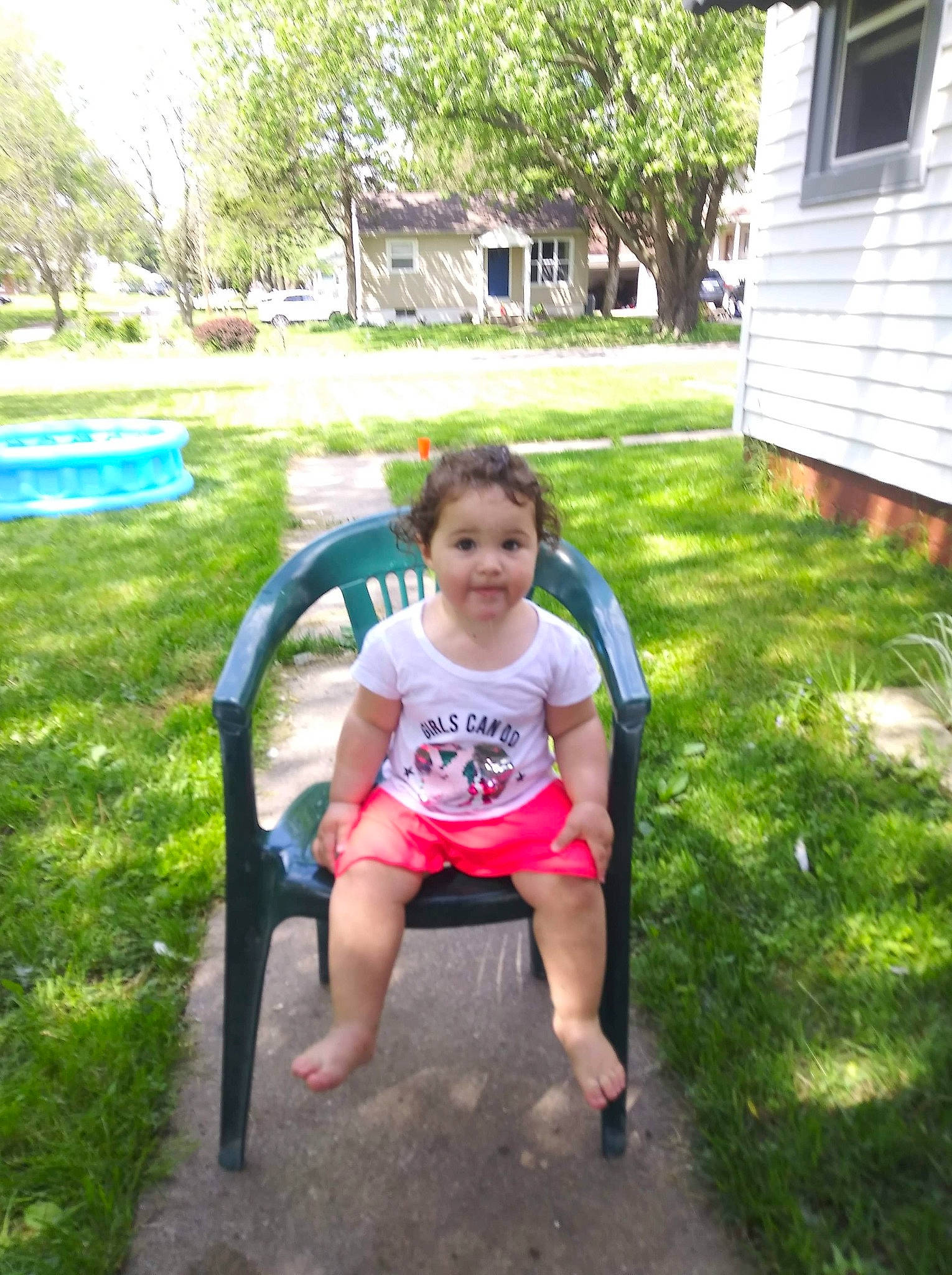 Sophia is registered to the contest to win money with this photo: chair, fun, grass, green, head, house, lawn, leaf, leisure, people_in_nature, person, plant, recreation, shorts, summer, sunlight, t_shirt, tints_and_shades, toddler, tree