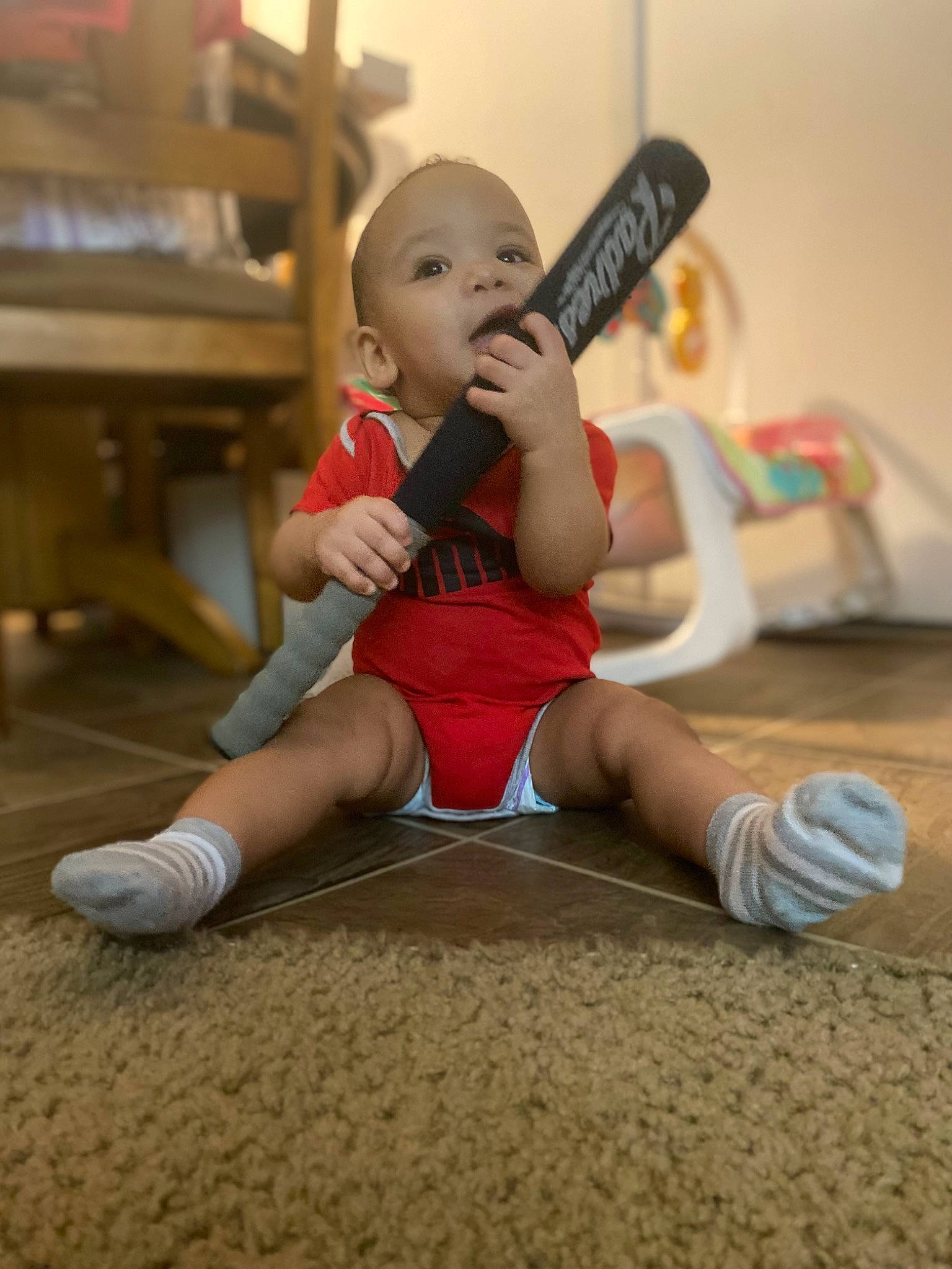 Bellamy is registered to the contest to win money with this photo: abdomen, balance, chest, elbow, floor, flooring, foot, fun, happy, hardwood, hat, human_leg, joint, knee, musical_instrument, person, sportswear, thigh, thumb, trunk