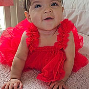 Amanda joined the competition — help win amazing prizes! baby, child, infant, crawling, red_dress, flower_headband, smiling, happy, indoors, bedroom, blanket, cute, portrait, hands, face, headwear, soft_lighting, skin, young_child, person