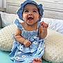 Amanda joined the competition — help win amazing prizes! baby, child, smiling, blue_dress, hat, cushion, indoor, happy, infant, portrait, cute, sitting, foot, hand, skin, clothing, headwear, person, bed, soft_furniture