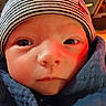 Grayson is registered to the contest to win money with this photo: baby, infant, child, portrait, close_up, face, eyes, nose, mouth, hat, beanie, striped_hat, scarf, bundled_up, winter, cozy, indoor, red_lighting, serious_expression, photography