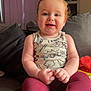 baby, child, infant, couch, clothing, sleeveless_shirt, pants, red_hair, blue_eyes, smiling, indoor, furniture, curtains, cabinet, blanket, home, person, portrait, sitting, cute