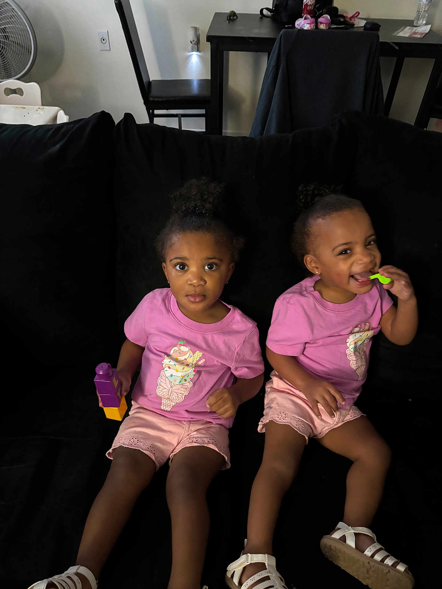 Amiah And Aminah joined the competition — help win amazing prizes! child, toddler, girl, pink_shirt, shorts, sitting, couch, black_couch, toy, blocks, smiling, playing, indoor, home, person, footwear, sandals, curly_hair, happy, cute