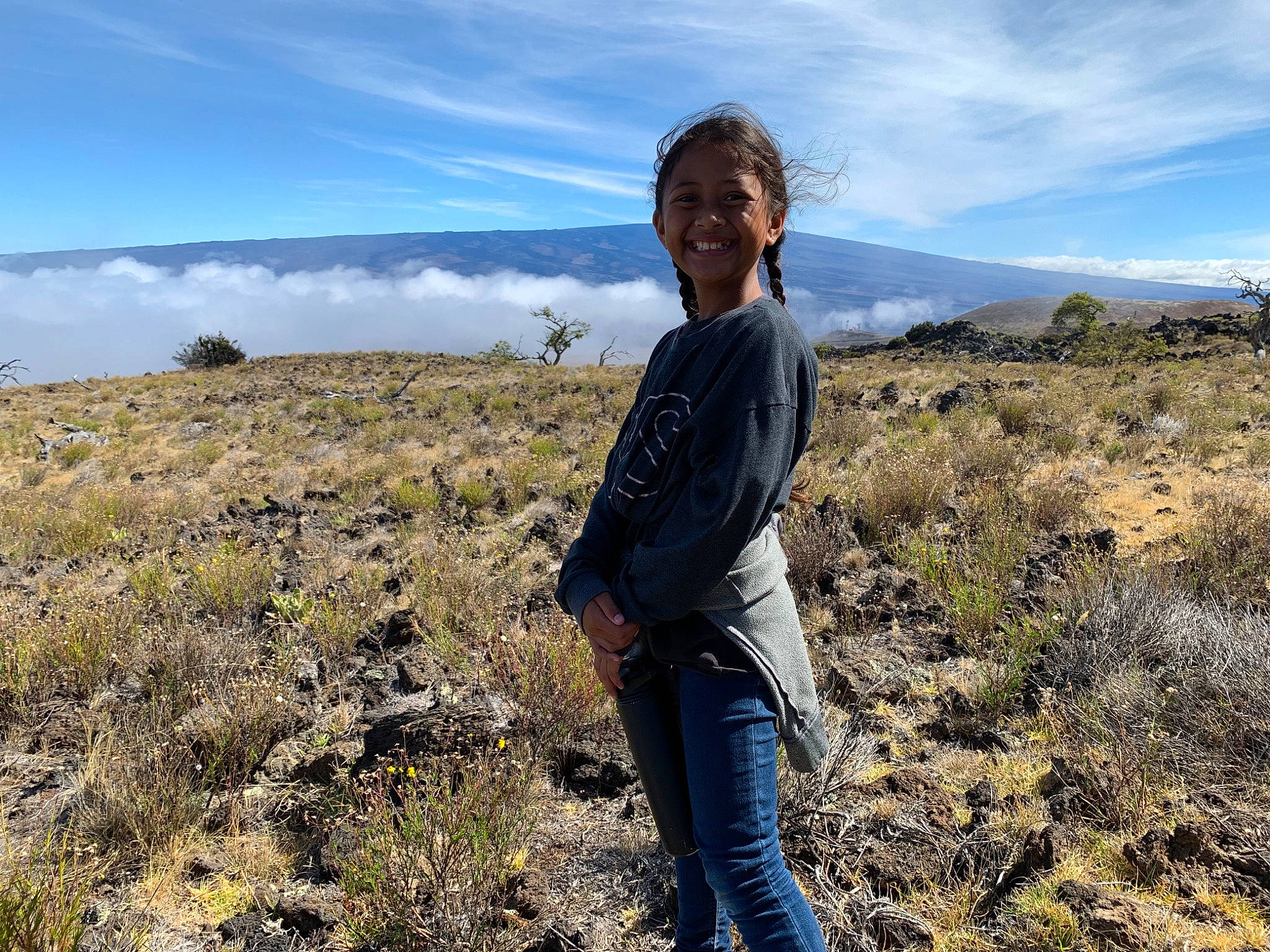 Amiliana joined the competition — help win amazing prizes! cloud, electric_blue, grass, grassland, happy, hill, jeans, joy, landscape, mountain, natural_landscape, people_in_nature, person, plain, plant, plant_community, prairie, rural_area, sky, smile