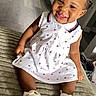 toddler, child, smiling, white_dress, red_bow, indoor, flooring, happy, sitting, baby_shoes, curly_hair, cute, portrait, person, young_child, home, carpet, candid, playful, fashion