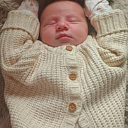 Ella joined the competition — help win amazing prizes! baby, sleeping, infant, cardigan, knitted, blanket, pajamas, floral_pattern, cozy, cute, hands_up, peaceful, soft, warm, child, newborn, portrait, indoors, resting, closeup