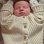 baby, sleeping, infant, cardigan, knitted, blanket, pajamas, floral_pattern, cozy, cute, hands_up, peaceful, soft, warm, child, newborn, portrait, indoors, resting, closeup
