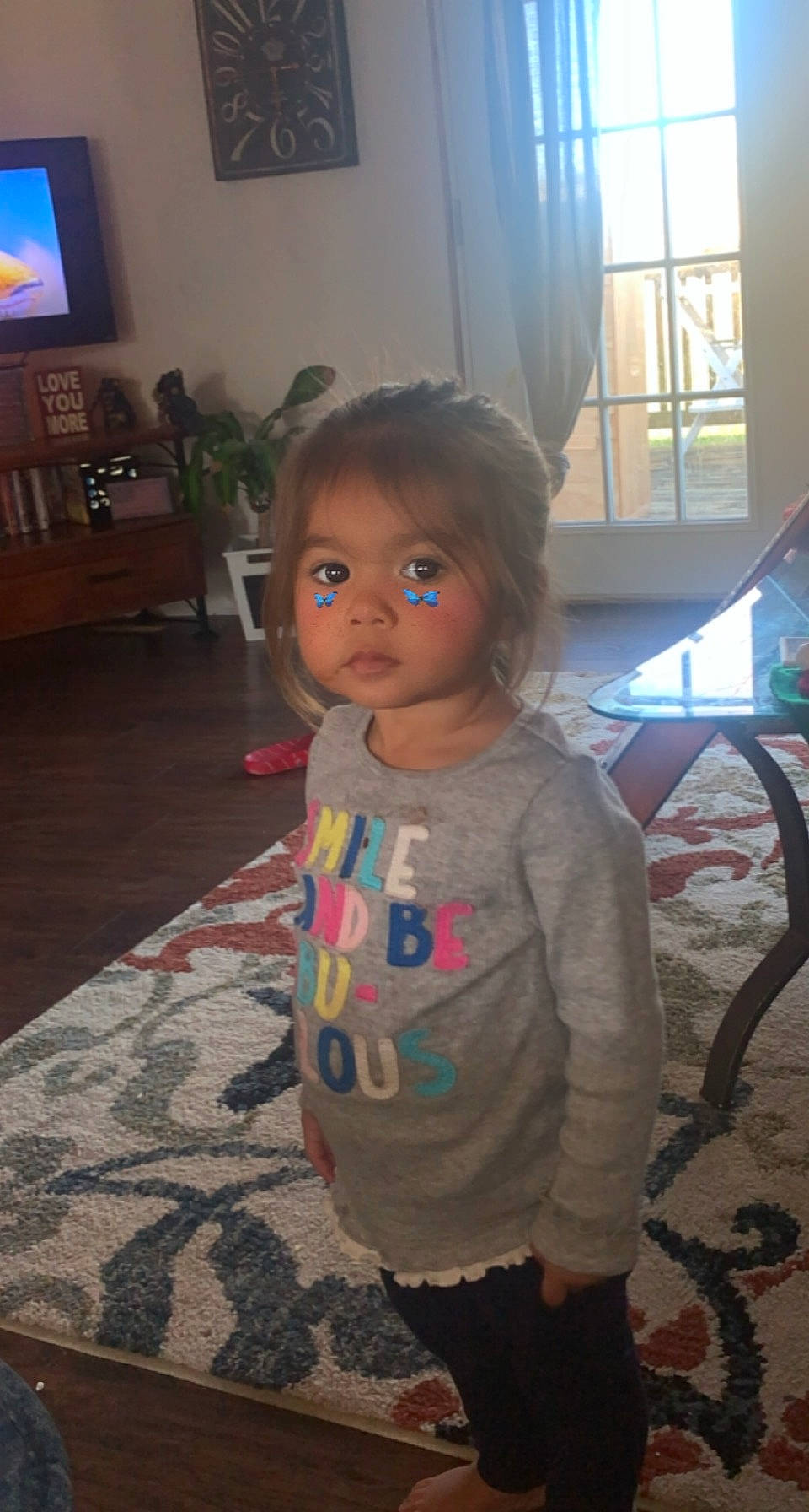 Adelina is registered to the contest to win money with this photo: chair, cheek, child, curtain, floor, flooring, fun, hardwood, head, houseplant, iris, person, picture_frame, room, sitting, skin, standing, television, toddler, vacation