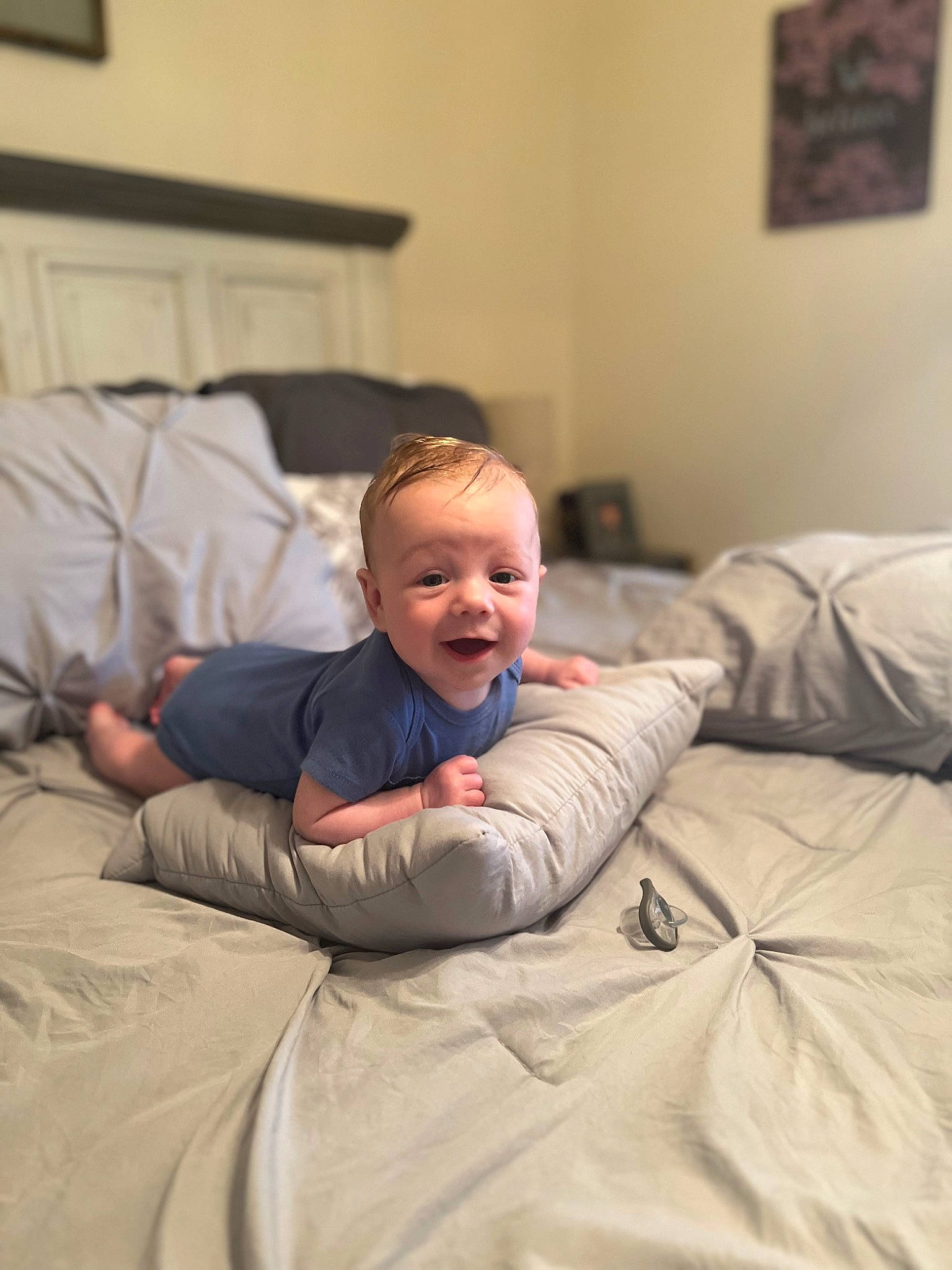 Kane is registered to the contest to win money with this photo: baby, child, comfort, event, flooring, fun, joy, linens, person, picture_frame, room, sitting, smile, toddler