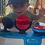 Ryder is registered to the contest to win money with this photo: baby, baseballcap, bodypart, cap, clothing, face, finger, footwear, furniture, hand, hat, head, outdoors, person, photography, portrait, shoe, shorts, table, wood