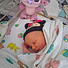 Daveena is registered to the contest to win money with this photo: newborn, baby, sleeping, blanket, plush_toy, mickey_mouse_hat, hospital_bassinet, animal_print, colorful, infant, cute, peaceful, child, soft_toy, bed, resting, wrapped, indoors, toy, portrait
