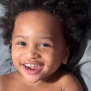 Jaciere joined the competition — help win amazing prizes! child, toddler, smiling, curly_hair, teeth, tongue, bare_chest, happy, face, portrait, skin, person, cute, lying_down, indoors, blanket, expression, joy, young, head
