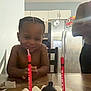 Jaciere joined the competition — help win amazing prizes! child, birthday_cake, candles, smiling, table, kitchen, refrigerator, cabinet, indoor, person, celebration, frosting, food, happy, braids, young, cake, home, shirtless, seated